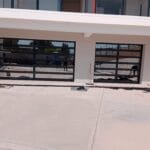 Two aluminium framed glass garage doors exterior installation