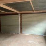 Interior view of two brown roll-up garage doors with automated motors installed
