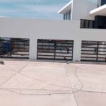 Three aluminium framed glass garage doors installed outside modern home