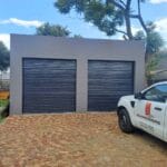 Double charcoal roll-up garage doors installed on modern garage facade
