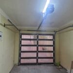 Frameless bronze glass single garage door interior installation