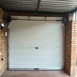 Interior view of green roll-up garage door showing installation and drum