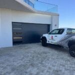 Modern narrow fluted charcoal aluminium garage door with window sections