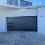Narrow charcoal fluted aluminium garage door with horizontal window panels