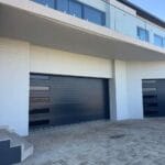 Slim charcoal aluminium garage door with fluted design and glass inserts