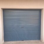 Charcoal roll-up garage door installed in residential exterior opening