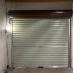 Interior view of brown roll-up garage door with motor and automation system