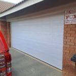 White aluzinc double garage door exterior with block panel design