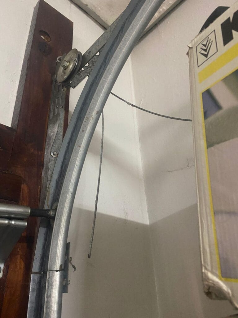 Garage door cable off track near top roller and rail system