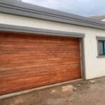Wide meranti slatted double garage door with natural wood finish