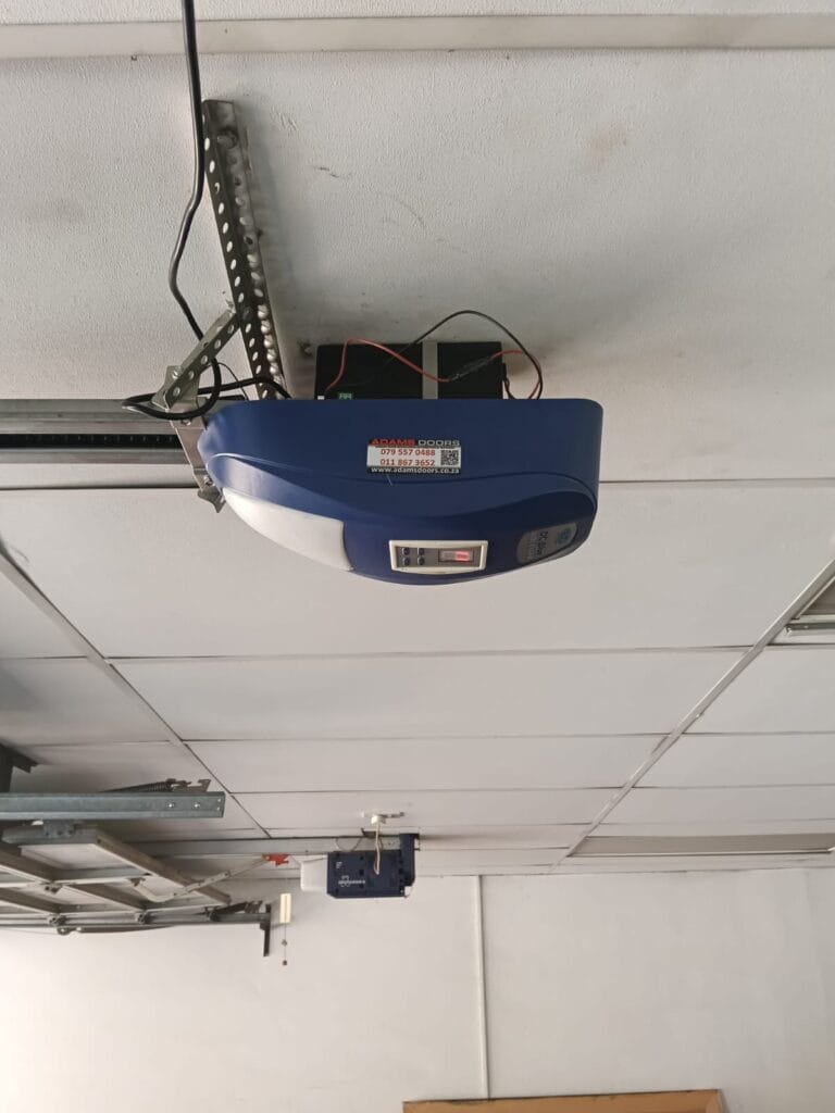 DC Blue Advanced garage door motor installed in commercial garage with suspended ceiling